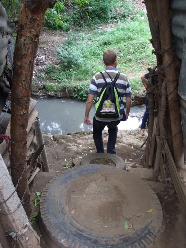 Nathan walking down their steps to leave - this is the "stream" of sewage the children jump every day to get to school and it's low now